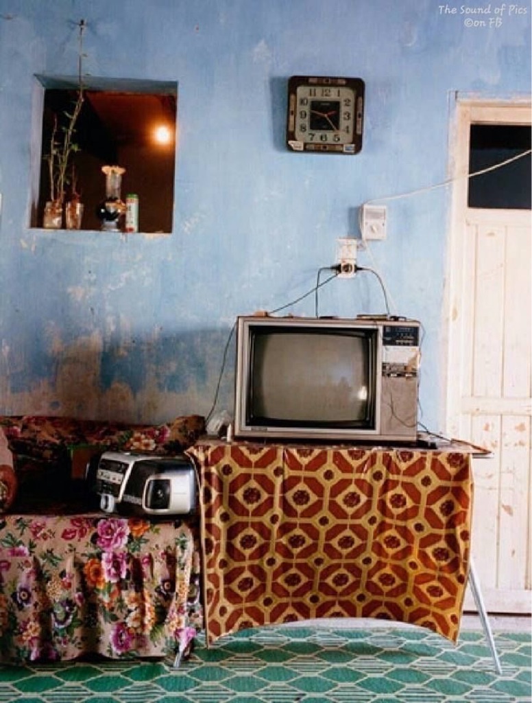 La foto presenta una acogedora sala de estar con un televisor vintage y un es...