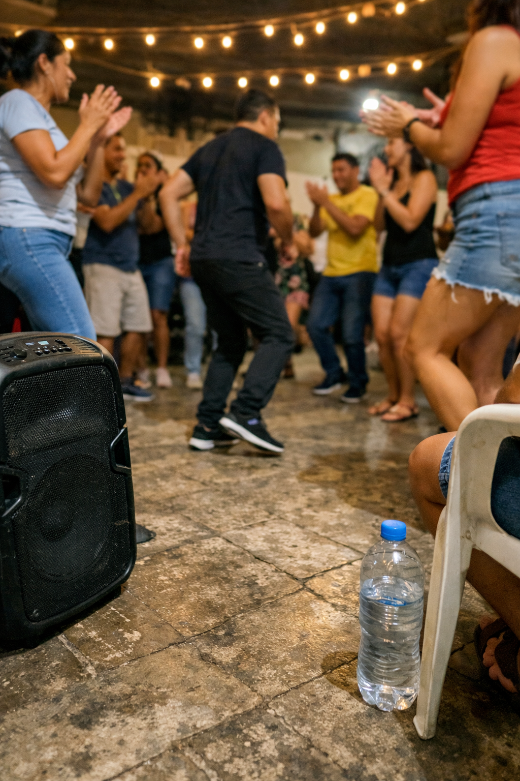 In the image, there are many people dancing and clapping at a party. The atmo...